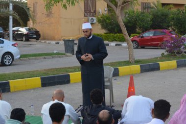 Kahire, Mısır, 21 Nisan 2023: Cami vaizi İmam, cami yakınlarındaki açık bir hava sahasında, Ramazan namazı ve kutlamalardan sonraki gün İslami kahvaltı şöleninde Kurban Bayramı 'nı düzenledi.