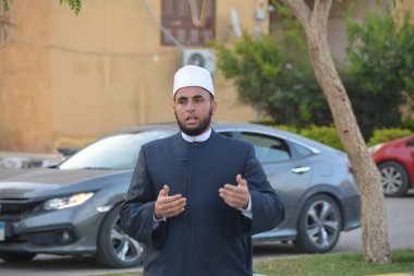 Kahire, Mısır, 21 Nisan 2023: Cami vaizi İmam, cami yakınlarındaki açık bir hava sahasında, Ramazan namazı ve kutlamalardan sonraki gün İslami kahvaltı şöleninde Kurban Bayramı 'nı düzenledi.