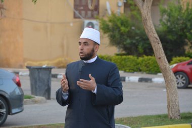 Kahire, Mısır, 21 Nisan 2023: Cami vaizi İmam, cami yakınlarındaki açık bir hava sahasında, Ramazan namazı ve kutlamalardan sonraki gün İslami kahvaltı şöleninde Kurban Bayramı 'nı düzenledi.