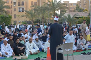 Kahire, Mısır, 21 Nisan 2023: Cami vaizi İmam, cami yakınlarındaki açık bir hava sahasında, Ramazan namazı ve kutlamalardan sonraki gün İslami kahvaltı şöleninde Kurban Bayramı 'nı düzenledi.