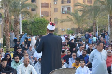 Kahire, Mısır, 21 Nisan 2023: Cami vaizi İmam, cami yakınlarındaki açık bir hava sahasında, Ramazan namazı ve kutlamalardan sonraki gün İslami kahvaltı şöleninde Kurban Bayramı 'nı düzenledi.