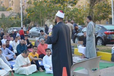 Kahire, Mısır, 21 Nisan 2023: Cami vaizi İmam, cami yakınlarındaki açık bir hava sahasında, Ramazan namazı ve kutlamalardan sonraki gün İslami kahvaltı şöleninde Kurban Bayramı 'nı düzenledi.
