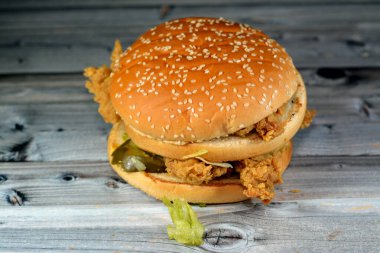 Hamburger ekmeğinin içinde üçlü Jalapeno tavuğu çıtır çıtır sandviç. 3 kızarmış tavuk parçaları, marul, domates, salatalık turşusu, çedar peyniri, acı biber parçaları ve biber sosu.