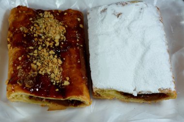 Elmalı turta, kremalı elma, tarçın ve şekerli bal şurubuyla doldurulmuş ve üzerinde şam fıstığı, fındık ve krema şekeri, lezzetli, tatlandırılmış elmalı turta servis edilmeye hazır, seçici bir odaklanma.