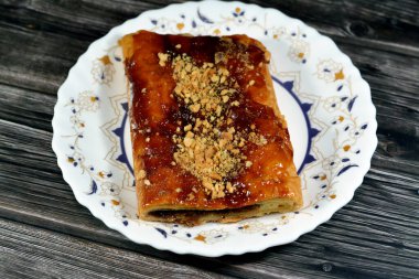 Elmalı turta, kremalı elma, tarçın ve şekerli bal şurubuyla doldurulmuş ve üzeri şam fıstığı ve fındıklı, lezzetli tatlandırılmış elmalı turta servis edilmeye hazır, seçici odaklanma.