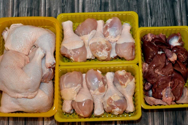 Fresh Raw chicken legs drumsticks hindquarter and thighs quarter and fresh uncooked chicken livers, gizzards and hearts, selective focus of fresh liver, gizzard and heart of chickens full of protein