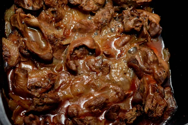 cooked chicken livers, gizzards and hearts, selective focus of fresh liver, gizzard and heart of chickens full of protein in a yellow disposable plate, protein cuisine of chicken parts