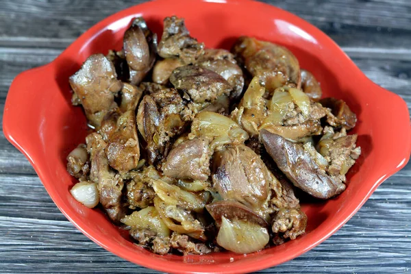 cooked chicken livers, gizzards and hearts, selective focus of fresh liver, gizzard and heart of chickens full of protein in a yellow disposable plate, protein cuisine of chicken parts