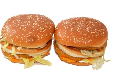 Ekmek arası tavuk köftesi, kıtır marul, eritme peyniri, soğan, turşu ve kızarmış susamlı çöreğin arasına çerçevelenmiş sosun lezzetli bir kombinasyonu. Çift tavuklu sandviç, seçici odaklanma.