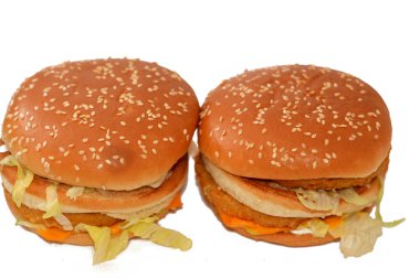 Ekmek arası tavuk köftesi, kıtır marul, eritme peyniri, soğan, turşu ve kızarmış susamlı çöreğin arasına çerçevelenmiş sosun lezzetli bir kombinasyonu. Çift tavuklu sandviç, seçici odaklanma.