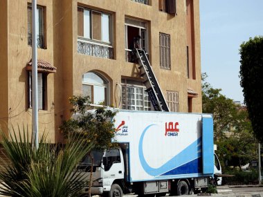 Kahire, Mısır, 11 Mayıs 2023: Mobilya teslimatı için elektrikli vinç aracı elektrikli vinç vasıtasıyla daireye taşınıyor mobilya taşımak için zahmetsiz nakliye aracı