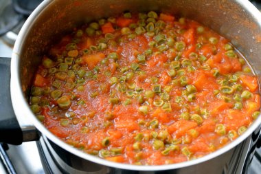 A vitamini, C vitamini, biraz kalsiyum minerali ve bağışıklık sisteminizi güçlendiren antioksidan ve yüksek fiber içerik içeren domates soslu pişmiş havuç ve bezelye dilimleri.