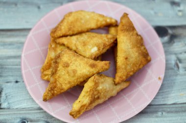 Bir samosa Singara, içinde baharatlı patates, soğan, bezelye, et ya da balık gibi malzemeler bulunan tuzlu bir Güney Asya hamur işi Sambousek genellikle Ramazan ayında Orta Doğu 'da tüketilir.