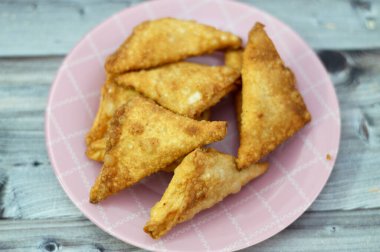 Bir samosa Singara, içinde baharatlı patates, soğan, bezelye, et ya da balık gibi malzemeler bulunan tuzlu bir Güney Asya hamur işi Sambousek genellikle Ramazan ayında Orta Doğu 'da tüketilir.