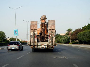 Kahire, Mısır, 20 Mayıs 2023: Bir inşaat alanına, yükleyici büyük ekipmanların bir çalışma yerine taşınması için kazıcı buldozer taşıyan büyük bir araç