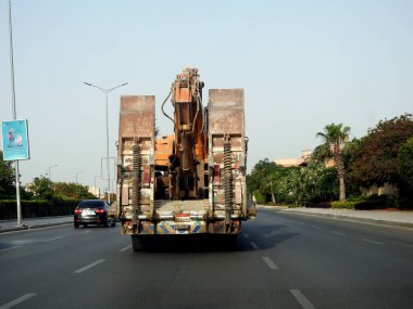 Kahire, Mısır, 20 Mayıs 2023: Bir inşaat alanına, yükleyici büyük ekipmanların bir çalışma yerine taşınması için kazıcı buldozer taşıyan büyük bir araç