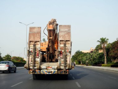 Kahire, Mısır, 20 Mayıs 2023: Bir inşaat alanına, yükleyici büyük ekipmanların bir çalışma yerine taşınması için kazıcı buldozer taşıyan büyük bir araç