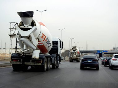 Kahire, Mısır, 16 Mayıs 2023: İnşaat alanına beton taşımak üzere yola çıkan beton ve çimento karıştırıcı kamyon, kum, çakıl ve su gibi toplamları birleştiriyor.