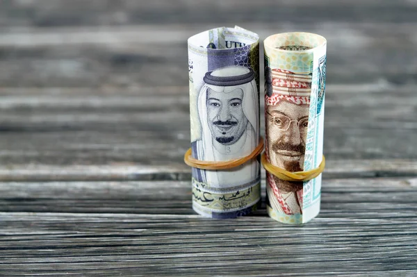 20沙特里亚尔20里亚尔钞票卷 沙特里亚尔钞票卷在橡皮筋上 上面印有国王Salman和国王Abdulaziz Saud的画像 以木料为背景 — 图库照片