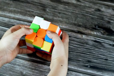 Kahire, Mısır, 26 Mayıs 2023: Bir çocuk tarafından Rubik Küpü 'nün çözülmesi, kombinasyon bulmacası, hız sihirli bulmaca küpü, altı yüzün her biri altı katı renkten her biri dokuz çıkartmayla kaplıydı.