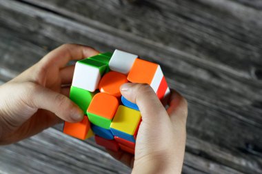 Kahire, Mısır, 26 Mayıs 2023: Bir çocuk tarafından Rubik Küpü 'nün çözülmesi, kombinasyon bulmacası, hız sihirli bulmaca küpü, altı yüzün her biri altı katı renkten her biri dokuz çıkartmayla kaplıydı.