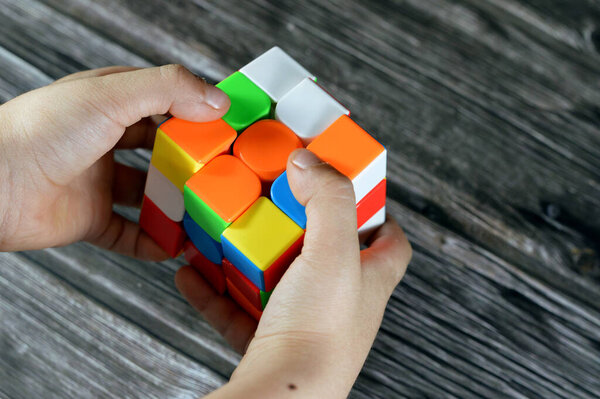 Cairo, Egypt, May 26 2023: Solving the Rubik's Cube by a child, combination puzzle, speed magic puzzle cube, each of the six faces was covered by nine stickers, each of one of six solid colors