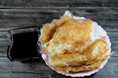 Mısırlı Feteer meshaltet, katmanlar üzerine katmanlar halinde hamur hamuru üzerine katmanlar halinde yağ ve şeker kamışı veya şeker pancarının rafine edilmesinden kaynaklanan yapışkan bir madde olan pekmez ile tereyağı arasında