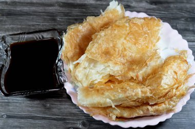 Mısırlı Feteer meshaltet, katmanlar üzerine katmanlar halinde hamur hamuru üzerine katmanlar halinde yağ ve şeker kamışı veya şeker pancarının rafine edilmesinden kaynaklanan yapışkan bir madde olan pekmez ile tereyağı arasında