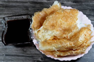 Mısırlı Feteer meshaltet, katmanlar üzerine katmanlar halinde hamur hamuru üzerine katmanlar halinde yağ ve şeker kamışı veya şeker pancarının rafine edilmesinden kaynaklanan yapışkan bir madde olan pekmez ile tereyağı arasında