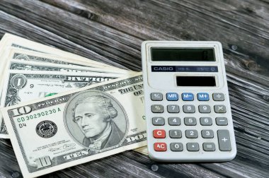 Kahire, Mısır, 31 Mayıs 2023: Casio Güneş enerjili hesap makinesi, el bilgisayarlı elektronik hesap makinesi, Amerikan para döviz kurları ve ekonomi konsepti ile Amerikan doları nakit para banknotları