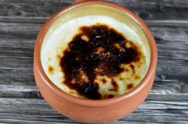 Fırında pilav, pirinç, mısır unu, şeker, su veya süt ve tarçın, vanilya gibi Riz au lait, stla, Sholezard ve moghli gibi diğer malzemelerle pişirilmiş pirinç pudingi güveci.