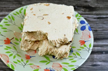 Badem ya da Halawa Tahiniya ile geleneksel tahin halkası, bu karışımın ana bileşenleri susam yağı ya da yapıştırıcıdır (tahini) ve şeker, glikoz ya da bal, temel tahini ve şeker bazlıdır.