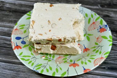 Badem ya da Halawa Tahiniya ile geleneksel tahin halkası, bu karışımın ana bileşenleri susam yağı ya da yapıştırıcıdır (tahini) ve şeker, glikoz ya da bal, temel tahini ve şeker bazlıdır.