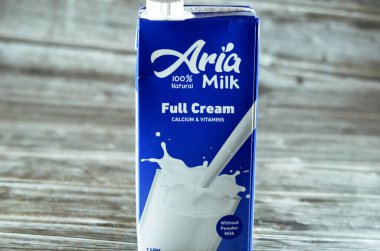 Kahire, Mısır, 5 Haziran 2023: Aria tam kremalı taze inek sütü şişesi bir litre kalsiyum ve vitaminli, seçici odak noktası Aria doğal sütü ahşap arka planda izole edilmiş