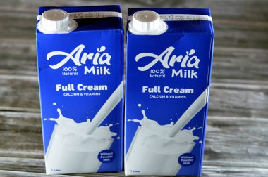 Kahire, Mısır, 5 Haziran 2023: Aria tam kremalı taze inek sütü şişesi bir litre kalsiyum ve vitaminli, seçici odak noktası Aria doğal sütü ahşap arka planda izole edilmiş