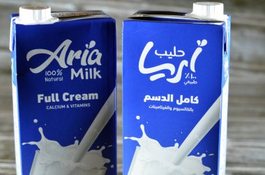 Kahire, Mısır, 5 Haziran 2023: Aria tam kremalı taze inek sütü şişesi bir litre kalsiyum ve vitaminli, seçici odak noktası Aria doğal sütü ahşap arka planda izole edilmiş