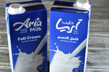 Kahire, Mısır, 5 Haziran 2023: Aria tam kremalı taze inek sütü şişesi bir litre kalsiyum ve vitaminli, seçici odak noktası Aria doğal sütü ahşap arka planda izole edilmiş
