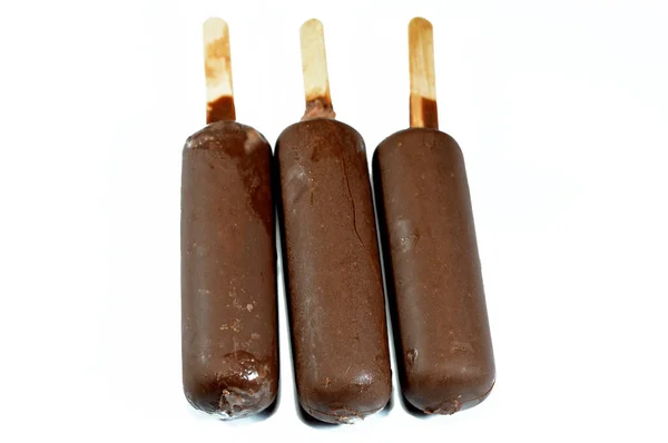 チョコレートアイスクリームスティックコーティングされ ダークチョコレートの層で覆われ 茶色のチョコレートクランチをクラックし チョコレートソースで詰めリッチ風味のアイスクリーム 冷凍アイスクリームスティック — ストック写真