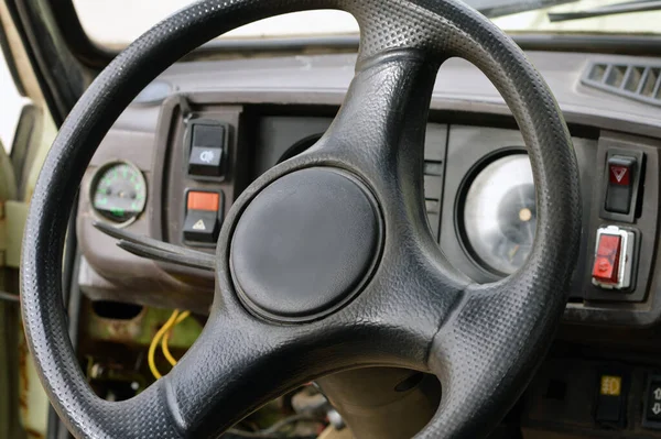 stock image Old car panel dashboard of seventies vehicle with speedometer, and buttons of lights and fan, leather steering wheel, selective focus of old vintage car from inside