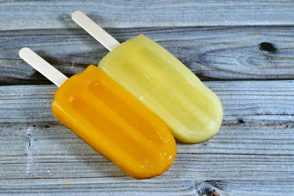 Frozen ice cream sticks of Mango and Pineapple, creamy and delicious frozen dessert, concept of confectionary summer times, frozen snack treats of ice-cream, selective focus of fruit iced creamy treat