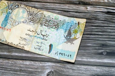 Katar Riyal nakit para biriminin 1 Katar banknotunun gözlemci yüzü Sütun, kemerler, yelkenli, palmiye ağaçları, çapraz kılıçlar, antika eski Katar faturası, seçici odak noktası