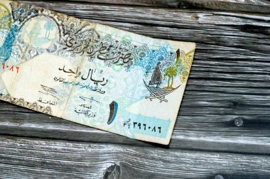 Katar Riyal nakit para biriminin 1 Katar banknotunun gözlemci yüzü Sütun, kemerler, yelkenli, palmiye ağaçları, çapraz kılıçlar, antika eski Katar faturası, seçici odak noktası