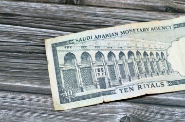 10 SAR Suudi Arabistan riyalinin ters tarafında nakit para birimi banknotu El-Mescid el-Haram (Kutsal Cami) kemerli El-Masa Duvarı, Mekke, eski model 10 riyal yer alıyor.