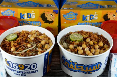 Kahire, Mısır, 15 Haziran 2023: Sayed Hanafy Koshary Koshari, pilav, makarna, spagetti ve mercimek karışımı baharatlı domates sosu, sarımsak sirkesi, kızarmış soğan, humus nohutu