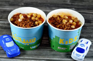 Kahire, Mısır, 15 Haziran 2023: Sayed Hanafy Koshary Koshari, pilav, makarna, spagetti ve mercimek karışımı baharatlı domates sosu, sarımsak sirkesi, kızarmış soğan, humus nohutu
