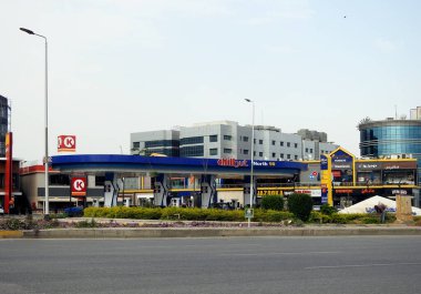 Kahire, Mısır, 3 Haziran 2023: Mavi gökyüzü, kuzey 90 ekseninde bir benzin istasyonu K, Bazooka, Papa Johns mağazaları ve istasyonun içindeki restoranlar