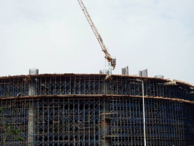Kahire, Mısır, 3 Haziran 2023: Mısır 'daki SAMCO şirketi için vinç kulesi ve yeni Kahire şehrinde çelik kolon yapısına sahip yeni binalar için iskeleleri olan bir inşaat sahası