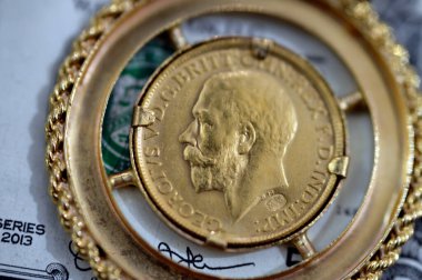 Amerikan dolarlarındaki mücevher veya mücevherler nakit para banknotu, İngiliz altın sikkeleri külçe para şekilleri George ve ejderha, Amerikan doları ve enflasyon konsepti olarak altın fiyat