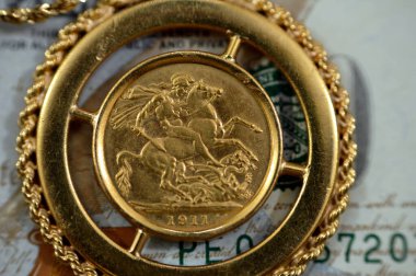 Amerikan dolarlarındaki mücevher veya mücevherler nakit para banknotu, İngiliz altın sikkeleri külçe para şekilleri George ve ejderha, Amerikan doları ve enflasyon konsepti olarak altın fiyat