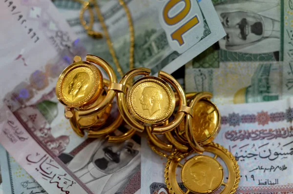 埃及镑和沙特阿拉伯里亚尔纸币货币与英国主权金币构成的金币形状的金币乔治珠宝或珠宝 黄金价格 — 图库照片